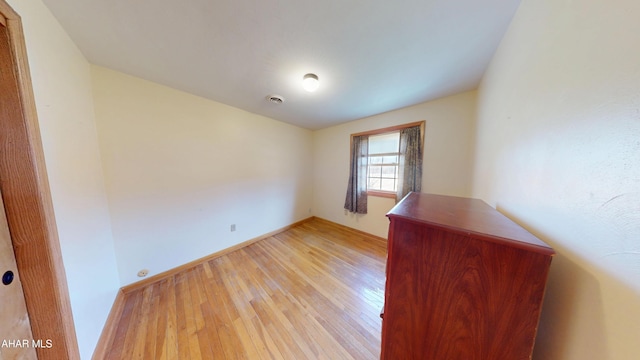 unfurnished room with visible vents and light wood-type flooring