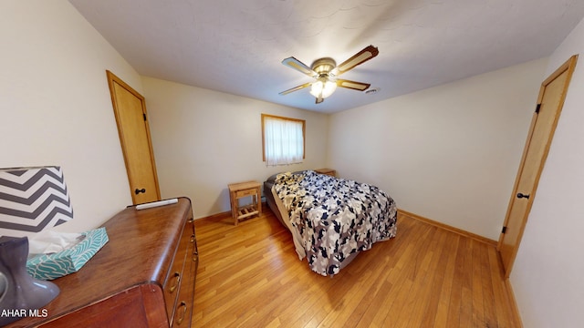 bedroom featuring baseboards, light wood-style floors, and a ceiling fan