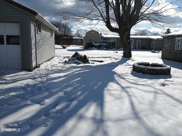 snowy yard featuring an outdoor fire pit