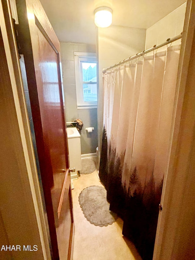 bathroom featuring toilet, vanity, and a shower with curtain