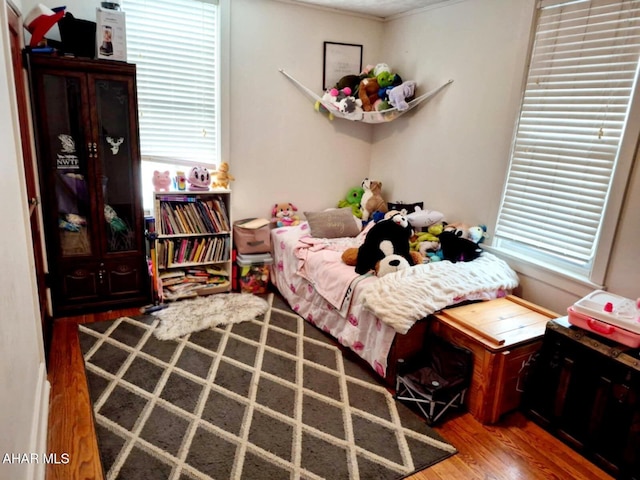 bedroom featuring multiple windows and wood finished floors