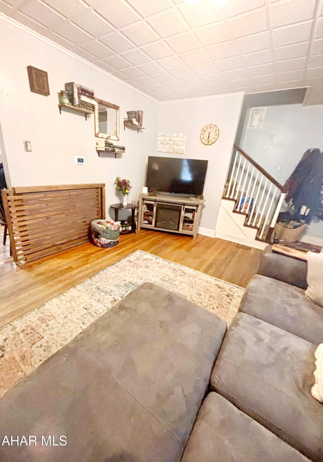 living area with stairway, baseboards, and wood finished floors