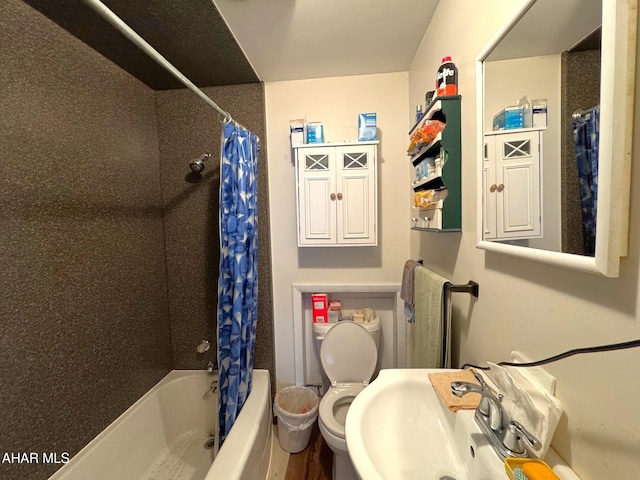 full bath with a sink, toilet, and shower / bath combo with shower curtain