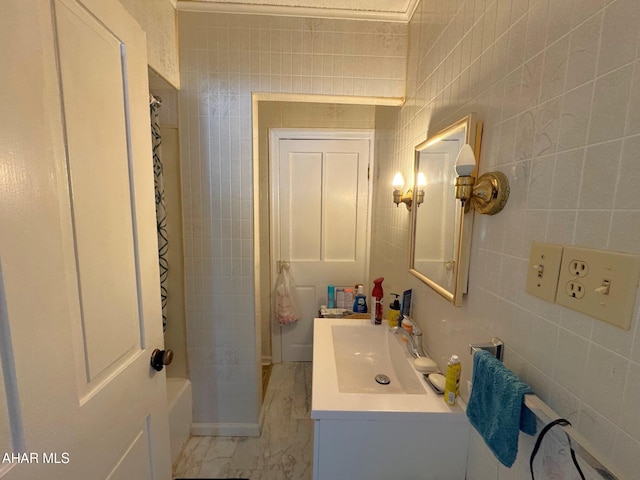 bathroom with shower / tub combo, marble finish floor, tile walls, and vanity