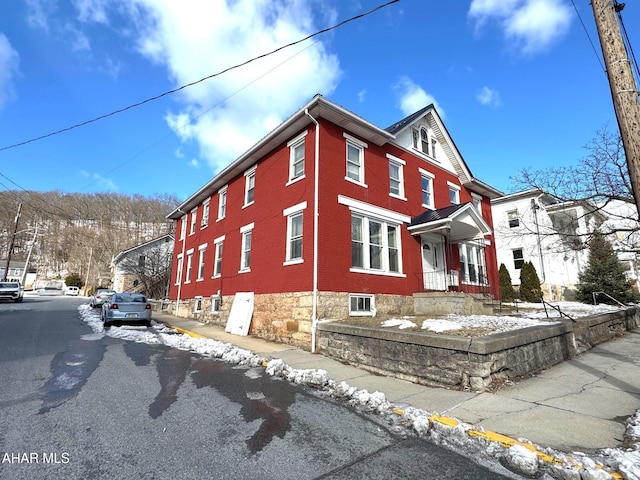 view of snow covered exterior with brick siding