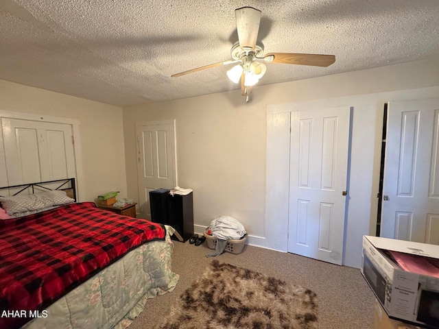 carpeted bedroom featuring a textured ceiling, a ceiling fan, and baseboards