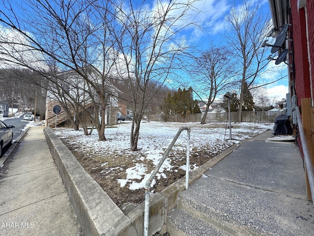 yard covered in snow featuring fence