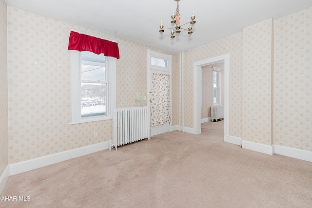 carpeted spare room with radiator heating unit and a notable chandelier