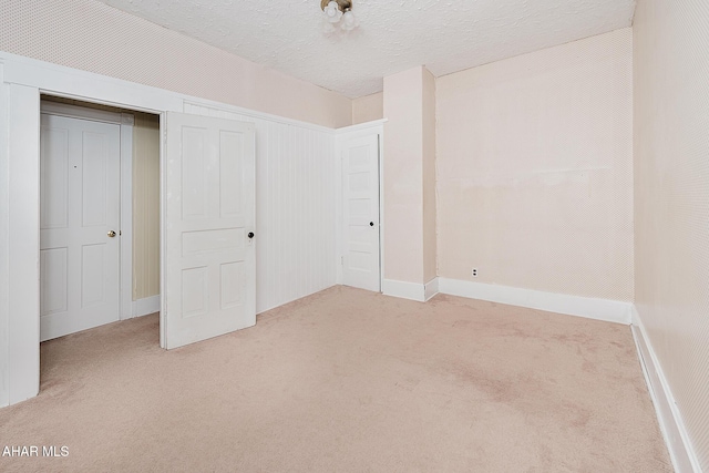 unfurnished bedroom with light colored carpet and a textured ceiling