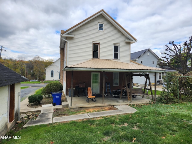 rear view of property with a patio area and a yard