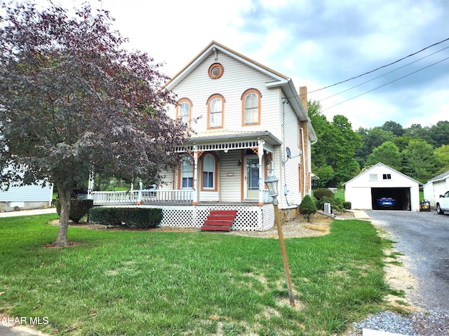 view of front of property with a porch, a front lawn, an outdoor structure, and a garage