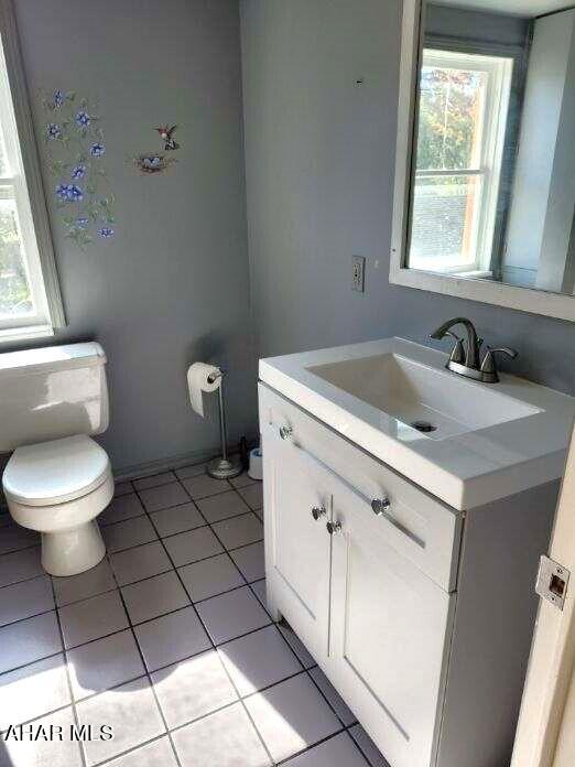 bathroom featuring tile patterned floors, vanity, toilet, and plenty of natural light