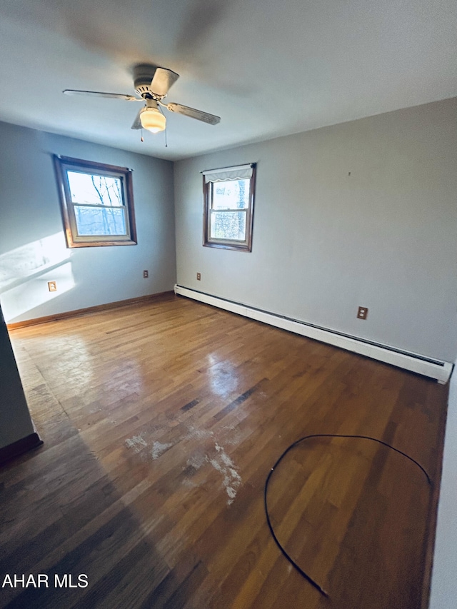 unfurnished room with hardwood / wood-style flooring, plenty of natural light, ceiling fan, and a baseboard heating unit