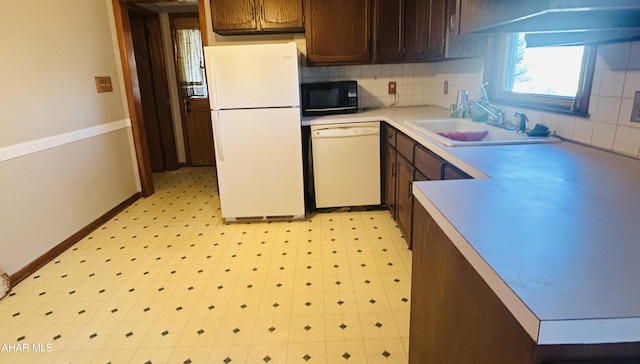 kitchen with backsplash, sink, and white appliances