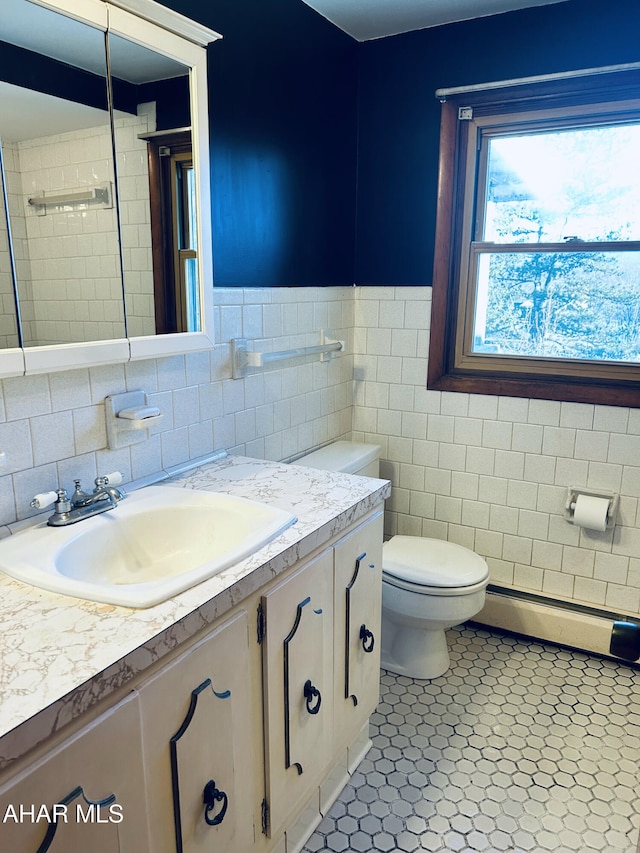 bathroom featuring a baseboard radiator, tile patterned floors, toilet, vanity, and tile walls