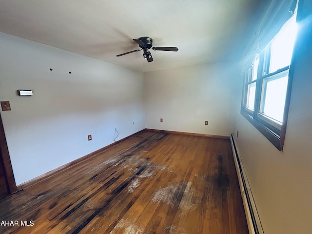 unfurnished room featuring ceiling fan, dark hardwood / wood-style floors, and a baseboard heating unit