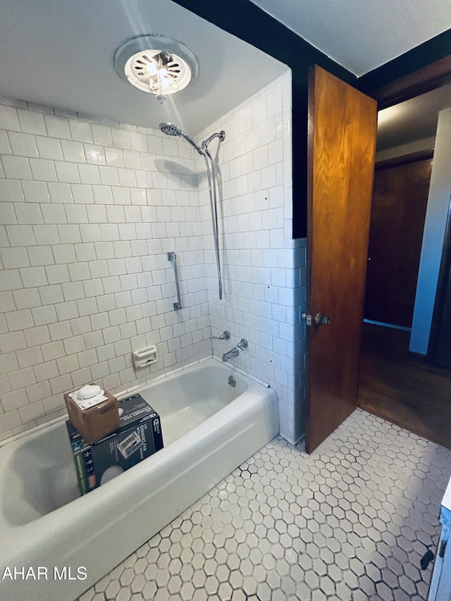 bathroom with tile patterned floors and tiled shower / bath