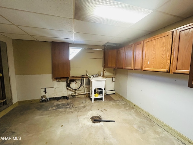 basement with a drop ceiling and sink