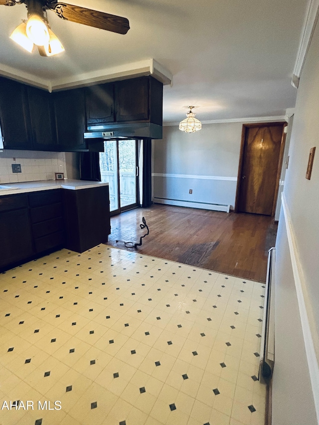 kitchen with ceiling fan, baseboard heating, backsplash, light wood-type flooring, and ornamental molding