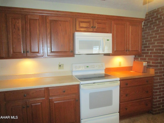 kitchen featuring white appliances and brick wall