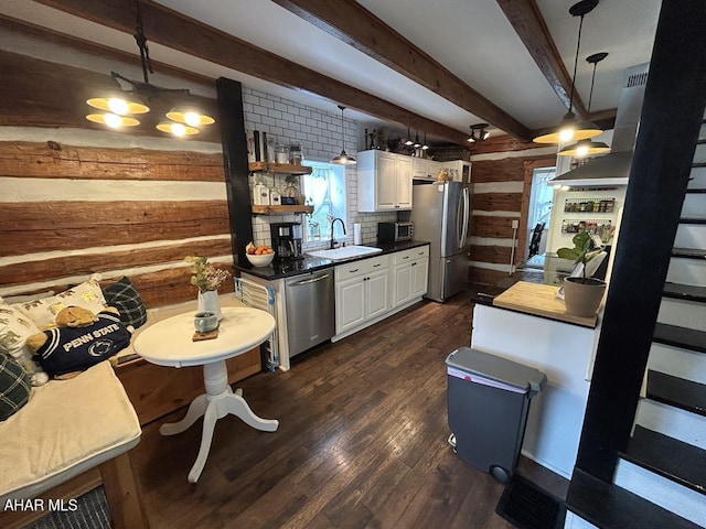 3776 Warriors Mark Path, Warriors Mark, PA 16877 - kitchen with stainless steel appliances, wood walls, a sink, beam ceiling, and white cabinetry