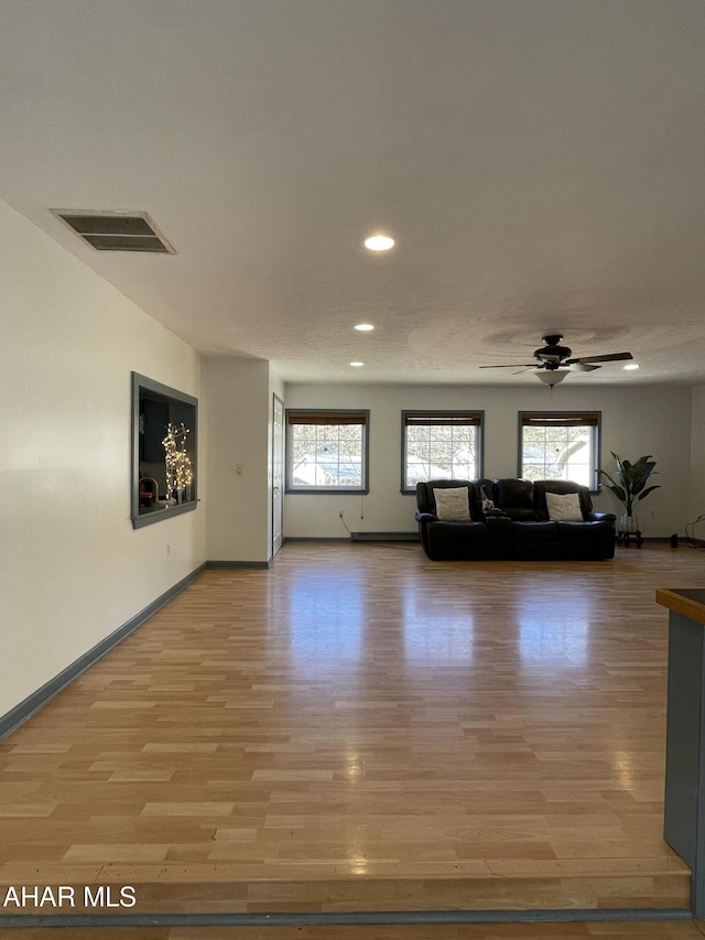 unfurnished living room featuring light hardwood / wood-style floors and ceiling fan