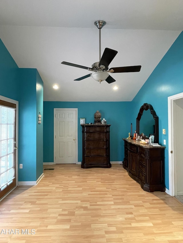 bedroom featuring ceiling fan, light hardwood / wood-style flooring, and lofted ceiling