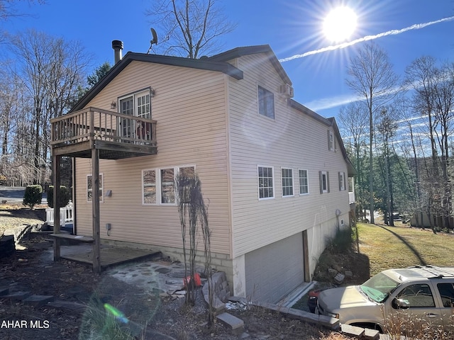 view of property exterior featuring a balcony and a garage