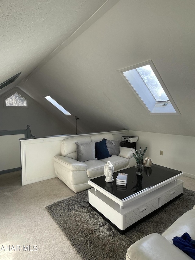 living room with vaulted ceiling with skylight, carpet floors, and a textured ceiling