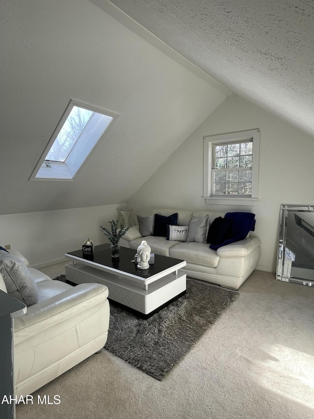 living room featuring carpet flooring, vaulted ceiling with skylight, and a textured ceiling