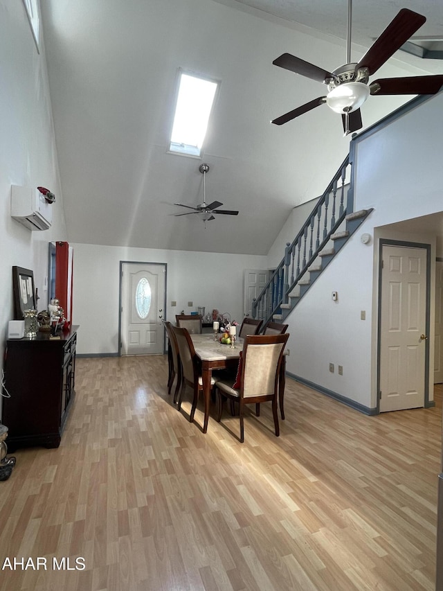 dining area featuring a wall unit AC, ceiling fan, light hardwood / wood-style flooring, and vaulted ceiling