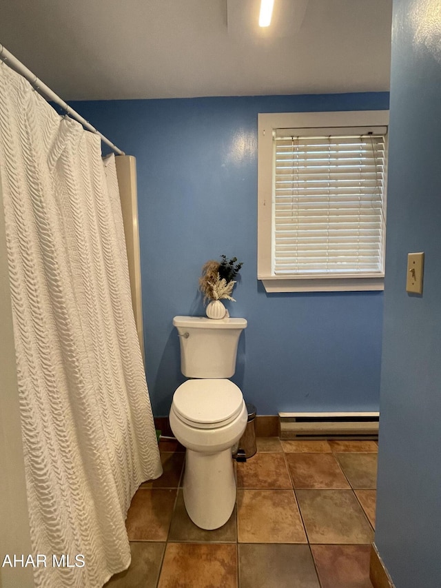 bathroom with tile patterned flooring, toilet, and baseboard heating