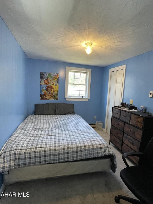 carpeted bedroom with a closet and a textured ceiling