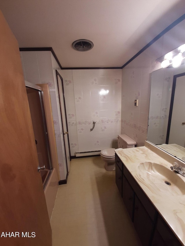 full bathroom featuring toilet, vanity, bath / shower combo with glass door, and a baseboard heating unit