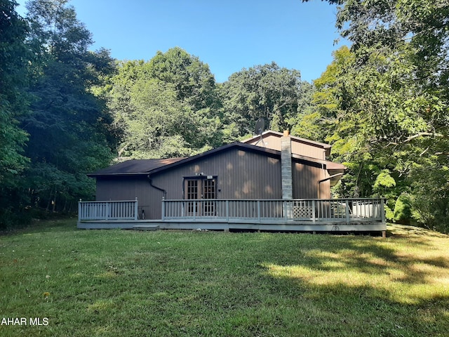 back of house with a wooden deck and a yard