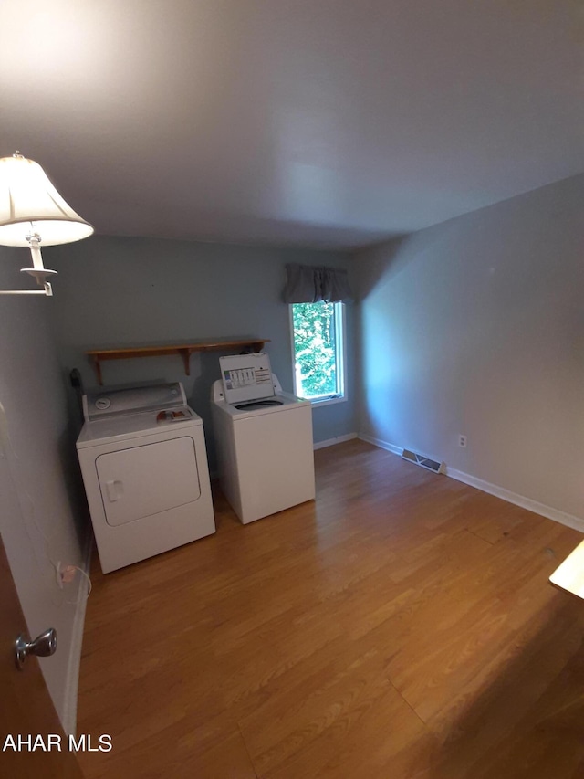 washroom featuring separate washer and dryer and hardwood / wood-style flooring