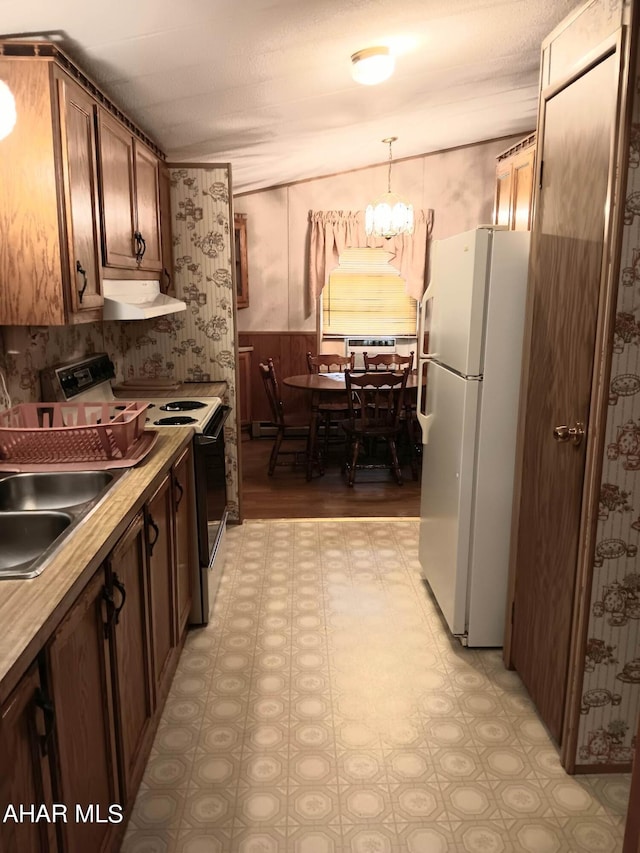 kitchen featuring decorative light fixtures, sink, white refrigerator, a notable chandelier, and electric range