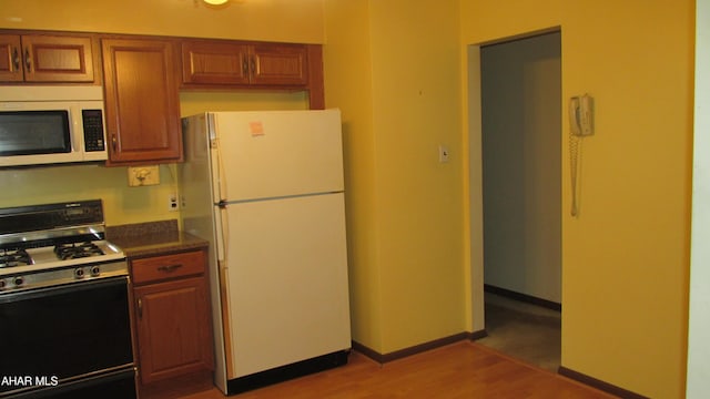 703 Ruskin Dr, Altoona, PA 16602 - kitchen featuring white appliances, light wood-style floors, and brown cabinets