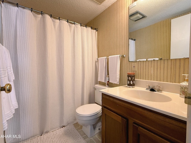 bathroom with vanity, a textured ceiling, and toilet