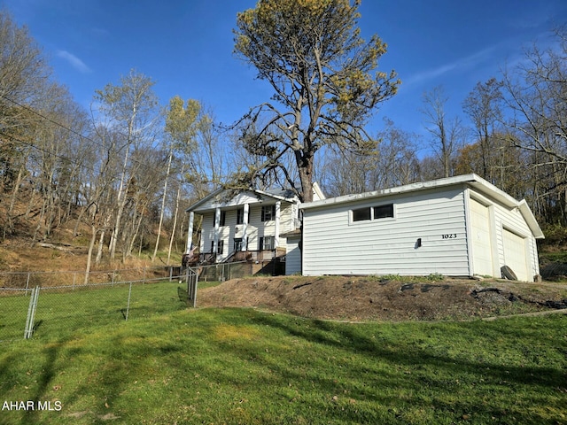 exterior space featuring covered porch, a yard, and a garage