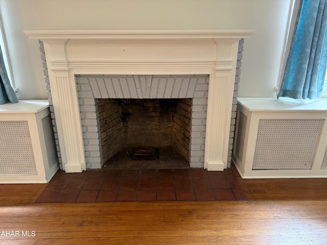 room details featuring wood finished floors and radiator heating unit