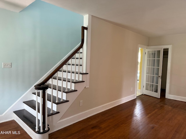 staircase with french doors, wood finished floors, and baseboards