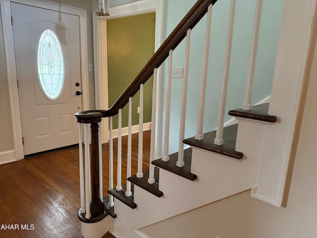 foyer featuring dark wood finished floors and stairs