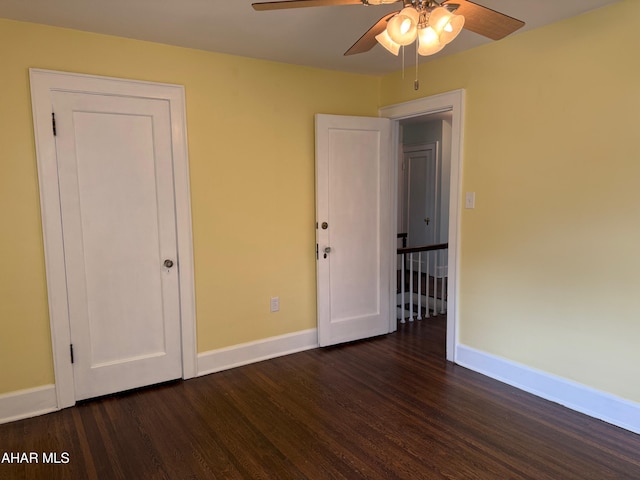 unfurnished bedroom featuring ceiling fan, baseboards, and dark wood-type flooring