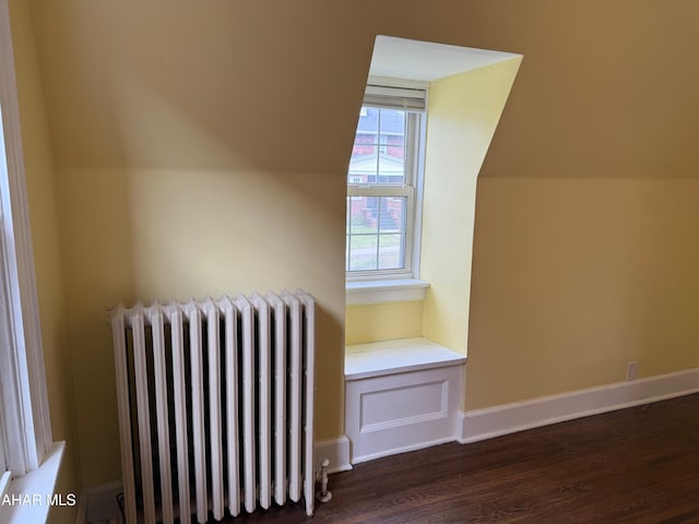 bonus room with radiator, dark wood finished floors, baseboards, and lofted ceiling