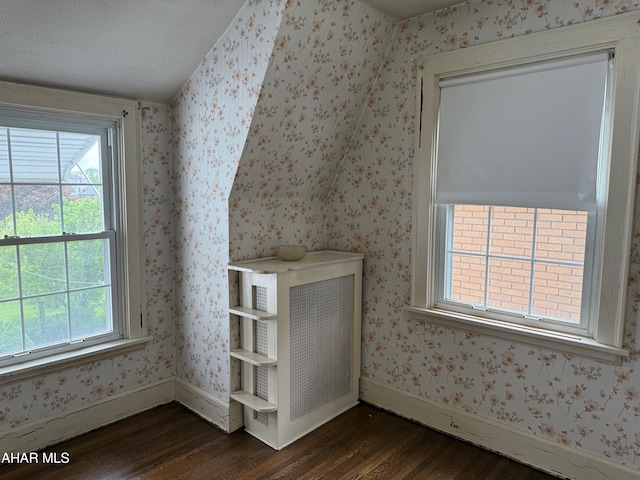 bonus room featuring wallpapered walls, baseboards, and dark wood-style floors