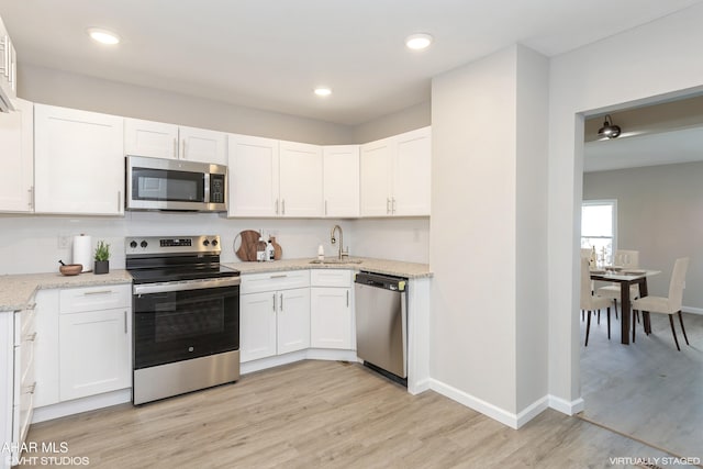 320 2nd Ave, Altoona, PA 16602 - kitchen with baseboards, light wood-style flooring, a sink, stainless steel appliances, and white cabinets