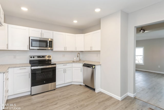 320 2nd Ave, Altoona, PA 16602 - kitchen with appliances with stainless steel finishes, white cabinetry, light wood-type flooring, and a sink