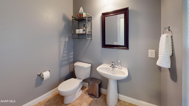 bathroom featuring toilet and baseboards