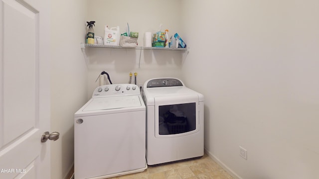 laundry room with laundry area, independent washer and dryer, and baseboards